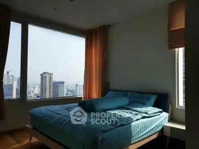 Spacious bedroom with stunning city view and large windows in modern apartment.