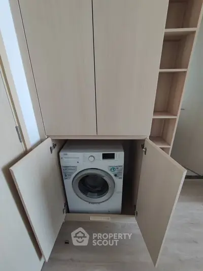 Modern laundry area with built-in washing machine in sleek wooden cabinetry.
