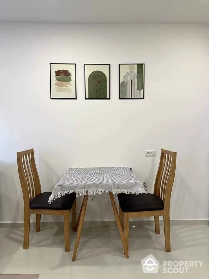 Cozy dining area with wooden chairs and modern art decor