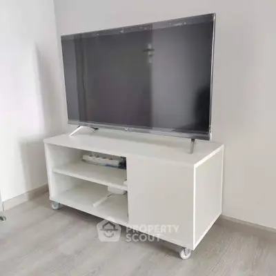 Modern living room with sleek TV stand and large flat-screen TV, perfect for entertainment.