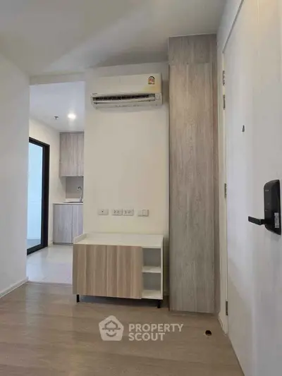 Modern apartment interior with air conditioning and sleek wooden cabinetry, showcasing minimalist design.