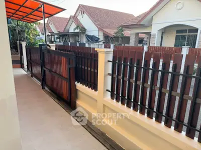 Charming residential neighborhood with red-tiled roofs and fenced pathways.