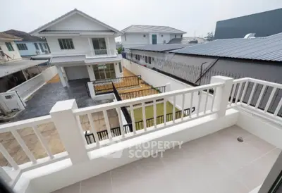 Spacious balcony with view of modern suburban houses and fenced yard.