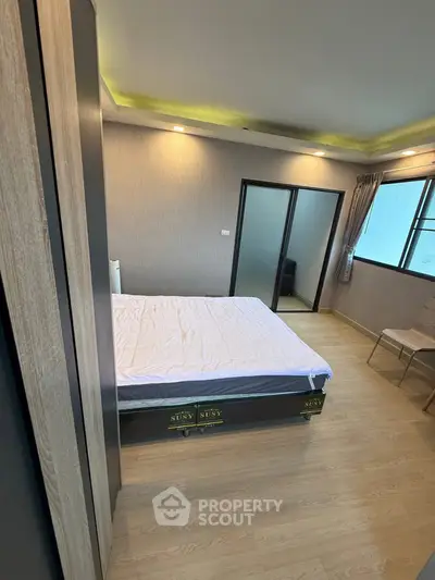 Modern bedroom with stylish decor and large window for natural light