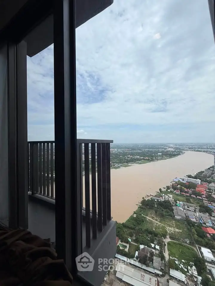 Stunning high-rise balcony view overlooking a scenic river and cityscape, perfect for urban living.