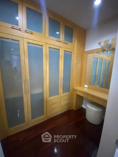 Spacious walk-in closet with wooden cabinetry and vanity area