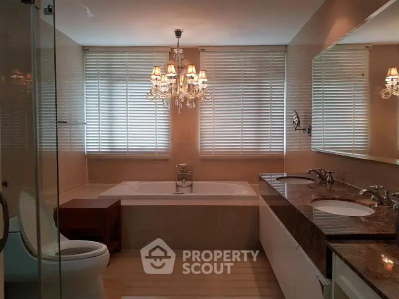 Luxurious bathroom with elegant chandelier and dual sinks