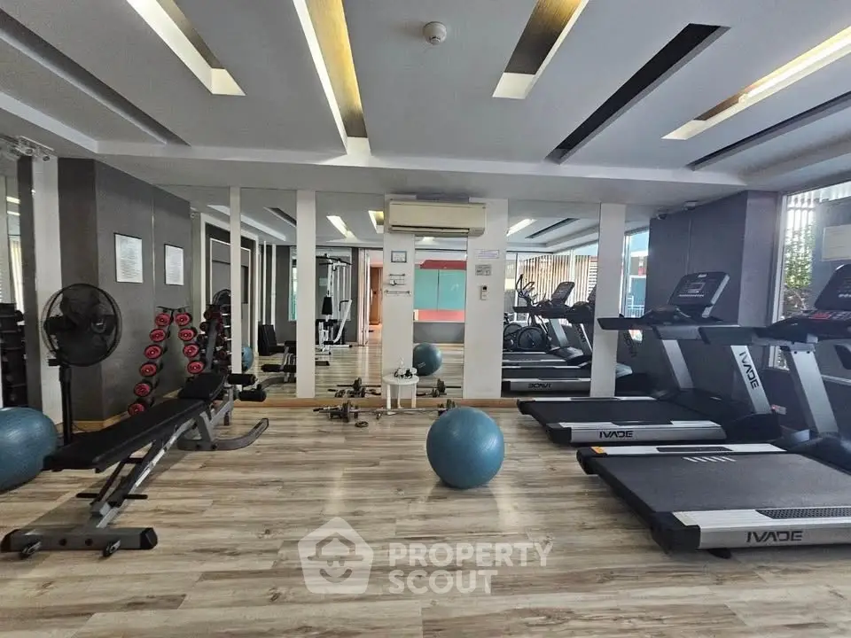 Modern gym with state-of-the-art equipment and stylish interior design in a luxury residential building.