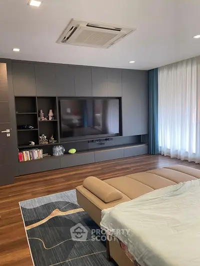 Modern bedroom with sleek built-in entertainment unit and cozy decor