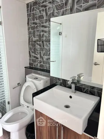 Modern bathroom with stylish black and white tiles and sleek fixtures.
