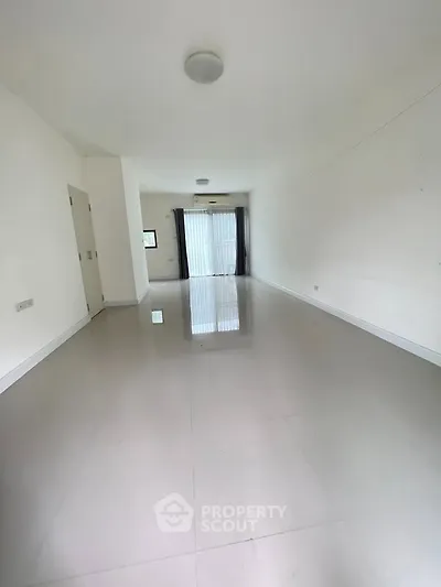 Spacious empty room with glossy tiled floor and large window
