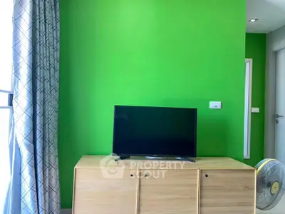 Modern living room with vibrant green accent wall and sleek TV setup.
