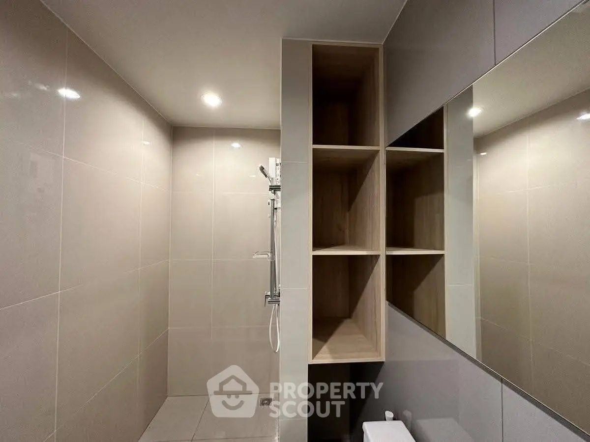 Modern bathroom with sleek tiles and built-in shelving