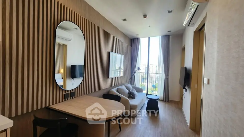 Modern living room with stylish decor and large window offering city view