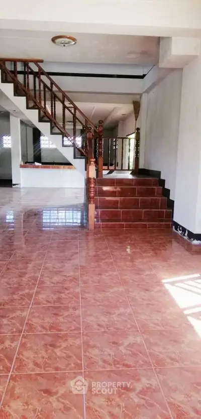 Spacious interior with elegant staircase and glossy tiled flooring