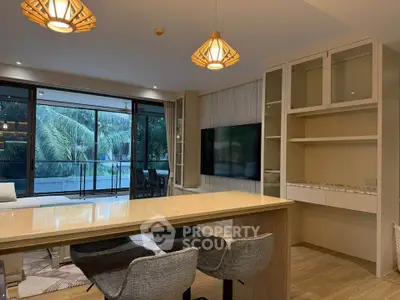 Luxurious open-plan living room with modern decor and large windows overlooking lush greenery.