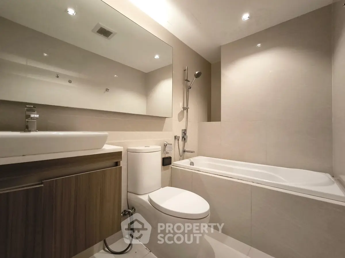Modern bathroom with sleek design featuring bathtub and elegant fixtures.
