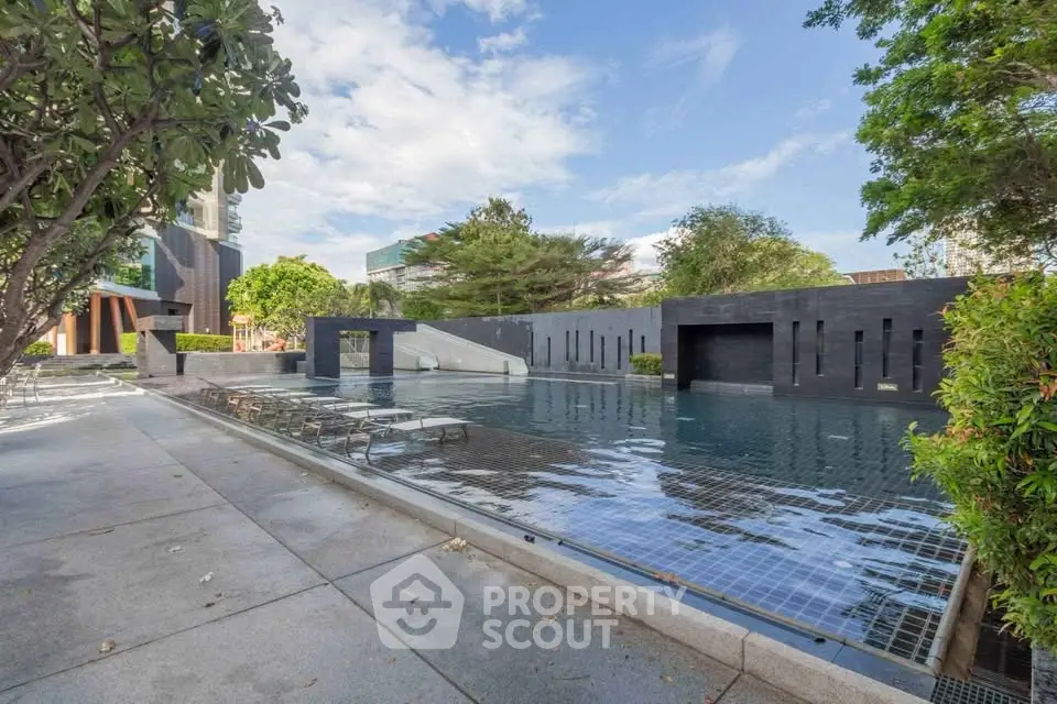 Luxurious outdoor pool area with modern design and lush greenery, perfect for relaxation and leisure.