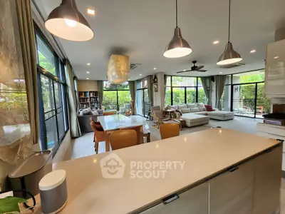 Spacious open-plan living room with modern decor and large windows