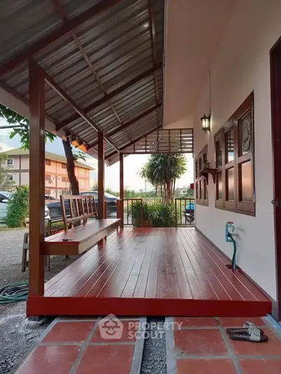 Charming wooden porch with seating and lush garden view, perfect for relaxation.