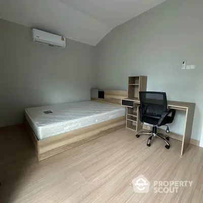 Modern minimalist bedroom with wooden flooring and study desk