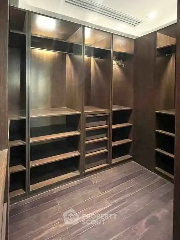 Spacious walk-in closet with elegant wooden shelving and ample storage space.