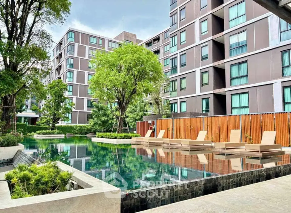 Luxurious modern apartment complex with serene pool and lush greenery