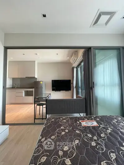 Modern open-plan living room with kitchen and stylish decor in a contemporary apartment.