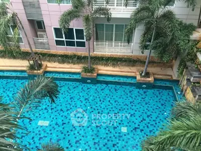 Luxurious apartment complex with a stunning swimming pool and lush palm trees, perfect for relaxation and leisure.