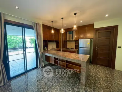 Luxurious kitchen with marble flooring and open layout, featuring modern appliances and elegant lighting.