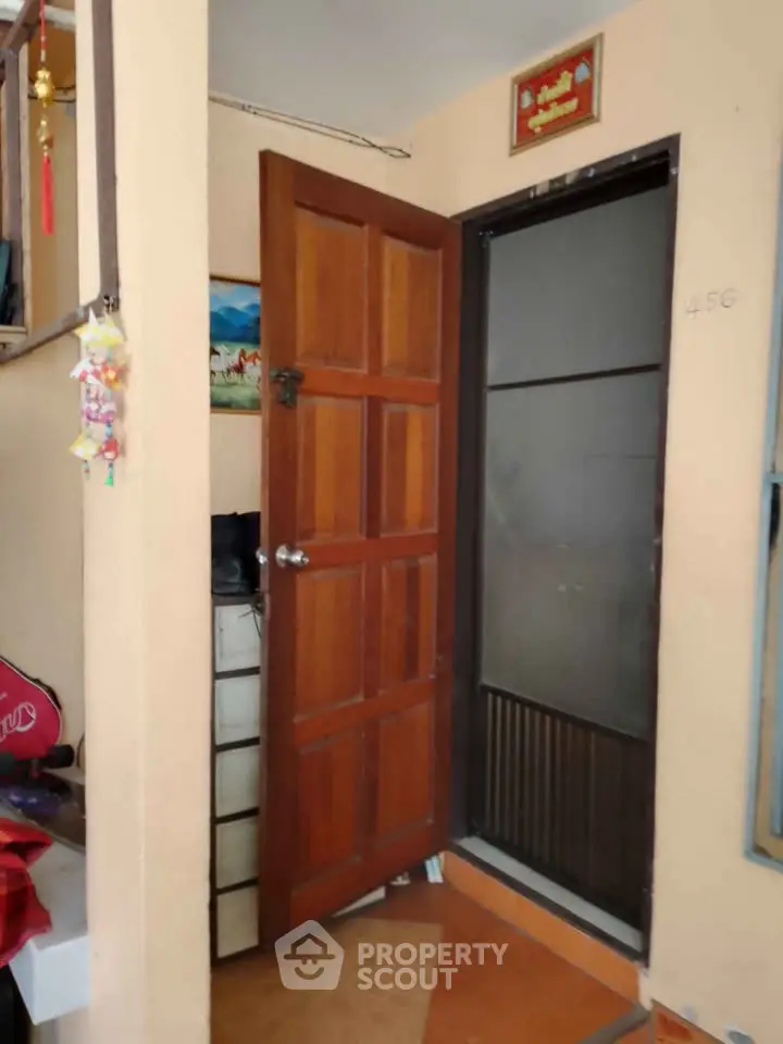 Cozy entrance with wooden door and decorative elements in a welcoming home interior.
