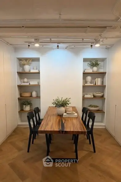 Stylish dining area with wooden table and modern decor in a contemporary apartment.