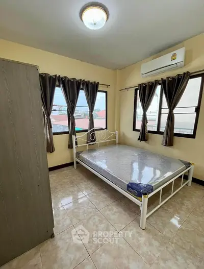Bright bedroom with large windows and air conditioning in modern apartment