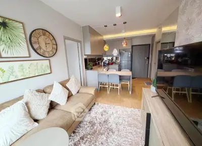 Modern living room with cozy sofa, stylish decor, and open kitchen layout in a contemporary apartment.