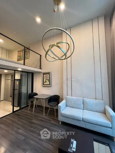 Modern loft-style living room with elegant lighting and cozy seating area