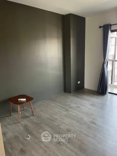 Spacious empty room with modern flooring and natural light, ideal for customization.