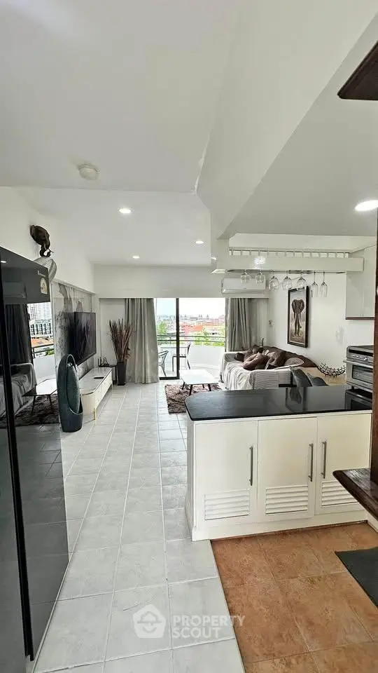 Modern open-layout living room with balcony and stylish decor, offering a bright and inviting atmosphere.