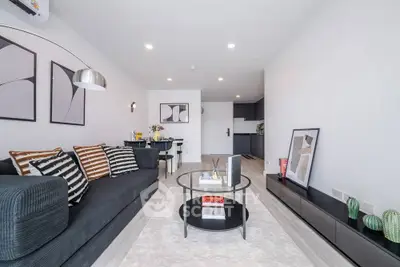 Modern living room with stylish decor and open layout, featuring a cozy sofa and elegant lighting.
