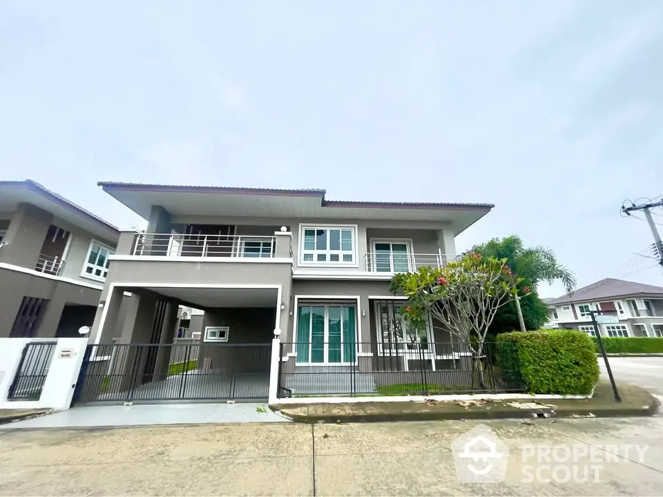 Modern two-story house with spacious driveway and lush greenery in a serene neighborhood.