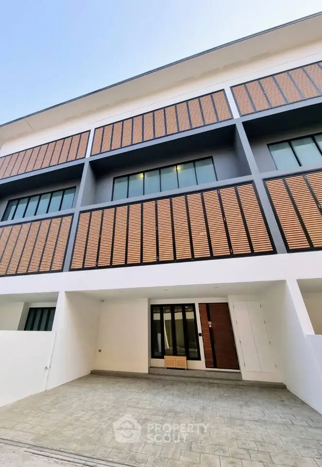 Modern townhouse exterior with stylish wooden accents and spacious driveway
