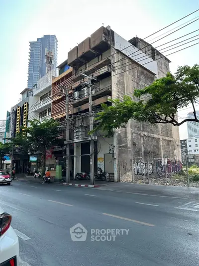 Urban street view of a multi-story building with graffiti, showcasing potential for renovation or development.