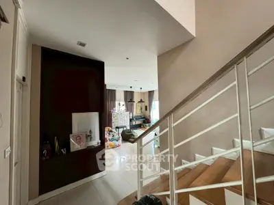 Spacious living area with modern staircase and natural light