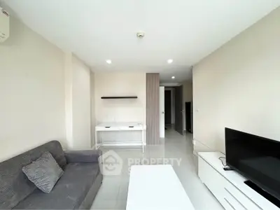 Spacious living room with modern furniture and natural light, perfect for relaxation and entertainment.