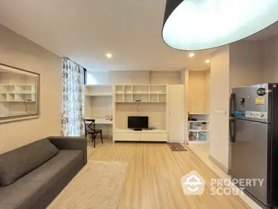 Modern living room with sleek furniture and open kitchen layout in a stylish apartment.