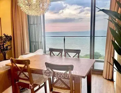 Stunning dining area with ocean view, wooden table, and modern lighting in a cozy apartment.