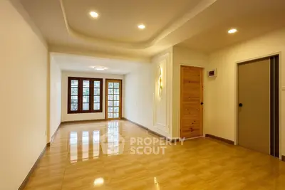 Spacious empty room with wooden flooring and elegant lighting, ideal for customization.