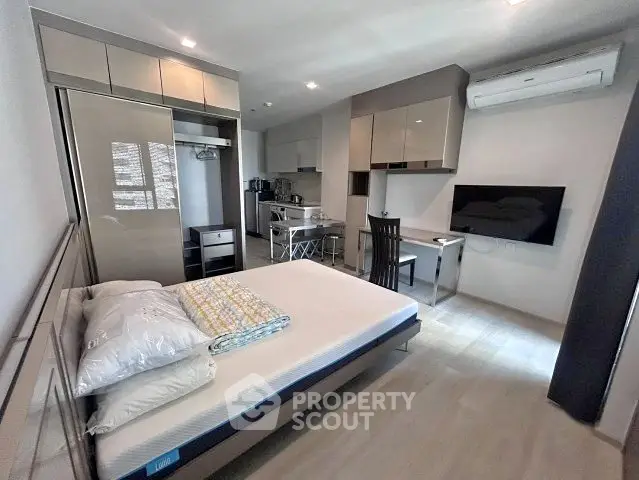 Modern studio apartment with sleek kitchen and cozy living area, perfect for urban living.