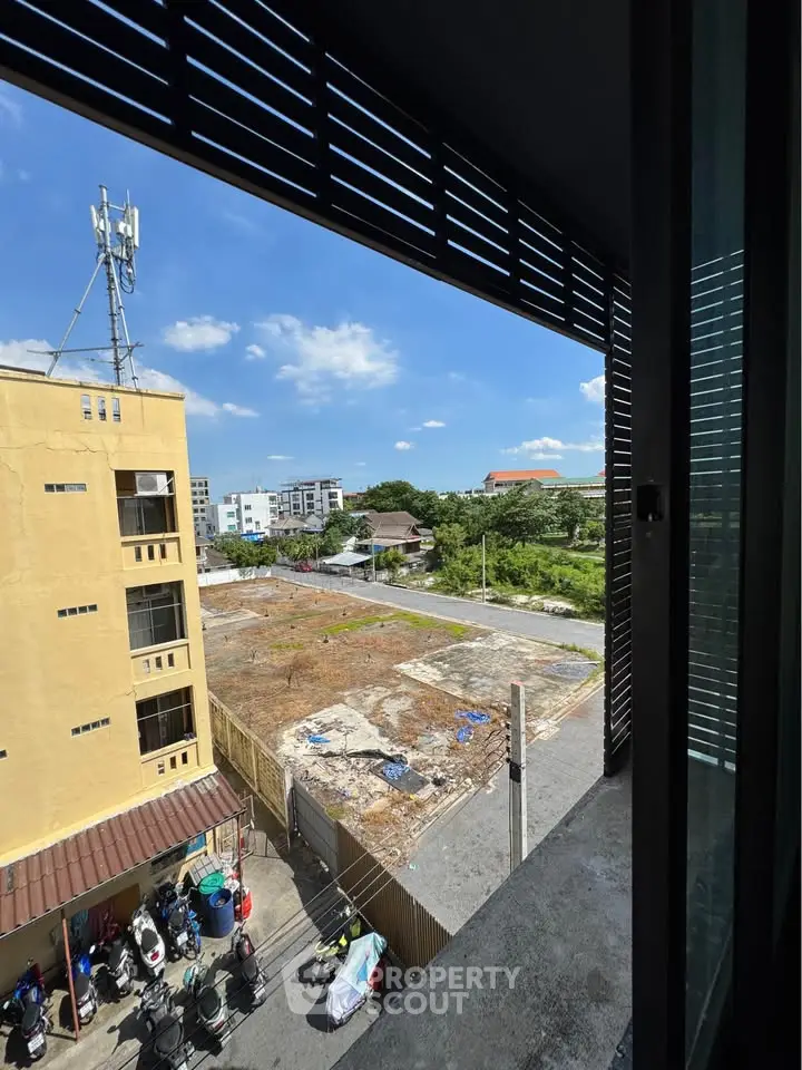 Stunning urban view from a high-rise balcony overlooking cityscape and greenery, perfect for modern living.
