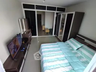 Spacious bedroom with modern decor and large mirrored wardrobe