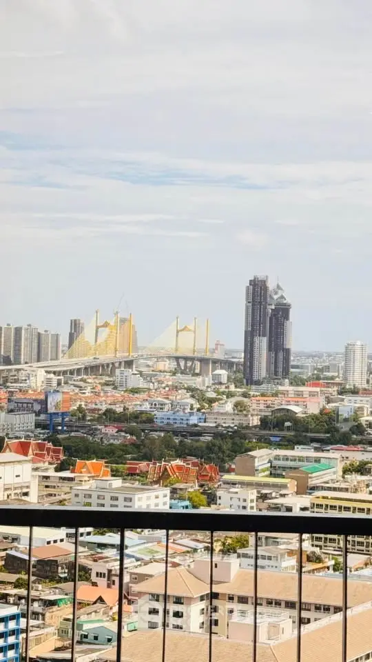 Stunning cityscape view with iconic bridge and skyline from high-rise balcony.
